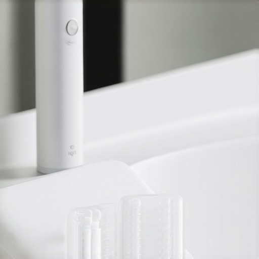 A high-end electric toothbrush and water flosser set on a clean marble bathroom counter.